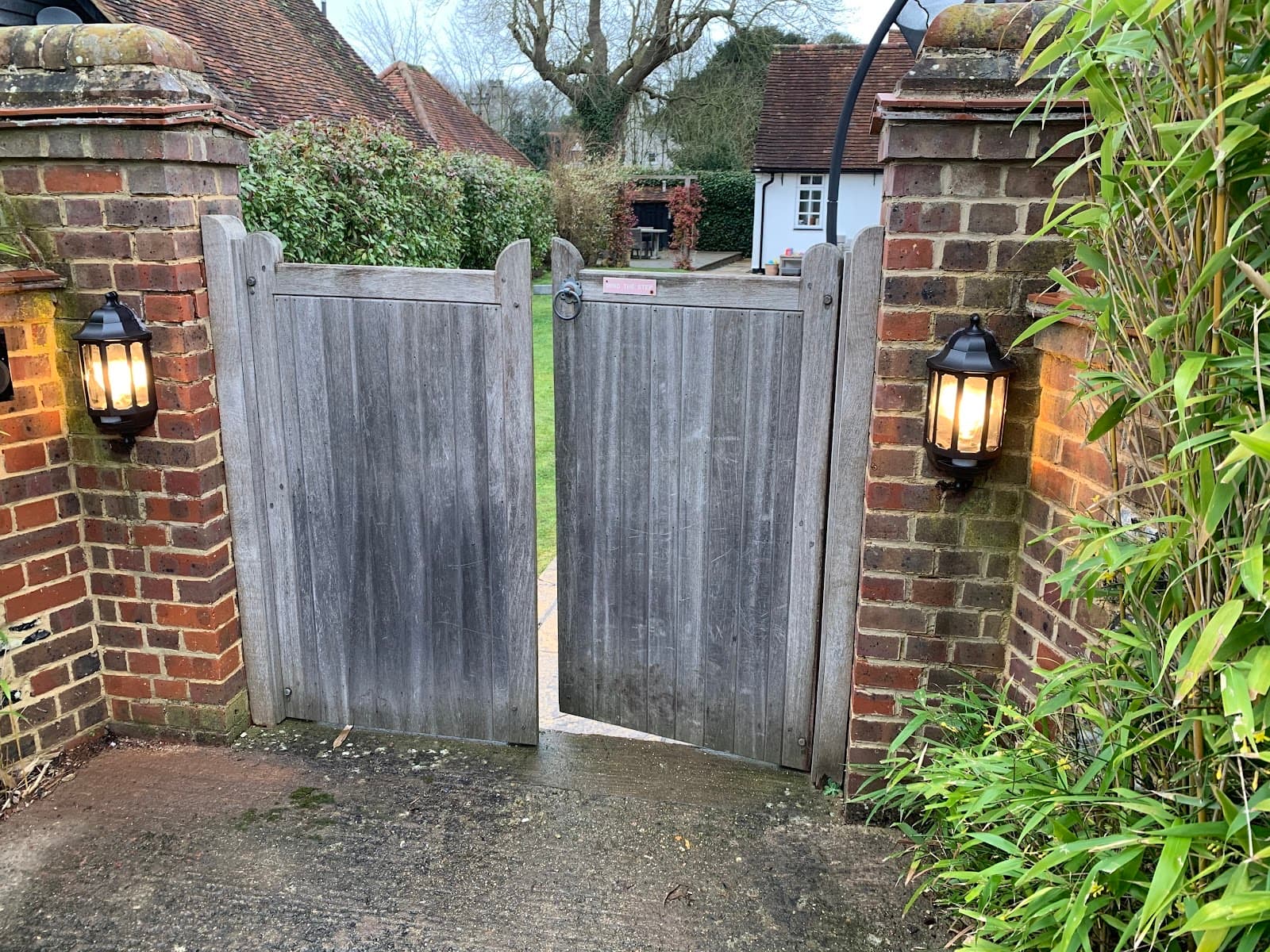 Lantern wall lights fitted either side of a garden gate