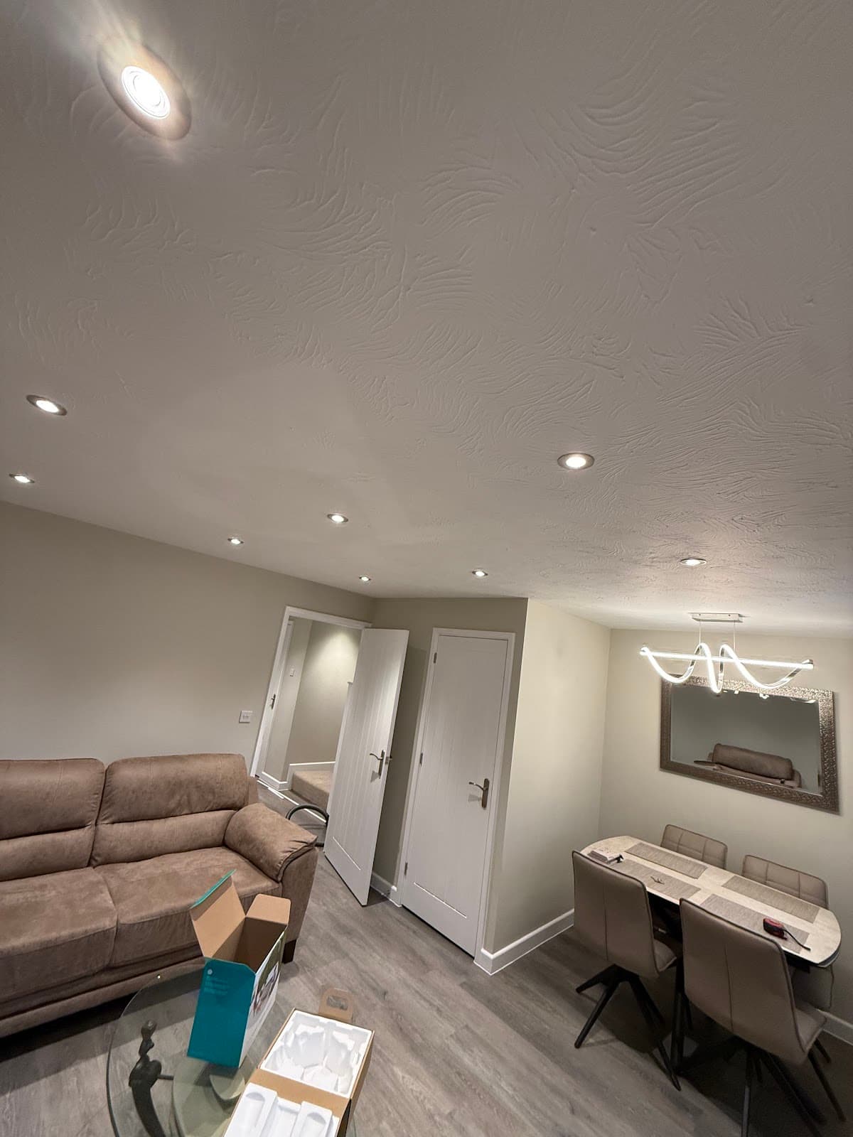Recessed downlights and a linear bar pendant in an open-plan living room